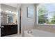 Bright bathroom featuring a garden tub, granite countertops, and dark cabinets at 1305 Kings Grove Dr, York, SC 29745
