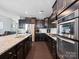 Spacious kitchen features stainless steel appliances, granite countertops and backsplash, gas cooktop, and dark wood cabinets at 1305 Kings Grove Dr, York, SC 29745