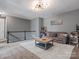 Open loft space with a cozy sofa, statement lighting, and a view of the staircase, perfect for relaxation at 1305 Kings Grove Dr, York, SC 29745