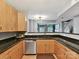 This kitchen shows stainless steel appliances and wood cabinets overlooking the great room at 1320 Fillmore Ave # 137, Charlotte, NC 28203