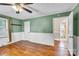 Bright bedroom with hardwood floors, ceiling fan, green walls, and an en suite bathroom at 1415 Midlake Rd, Kannapolis, NC 28083