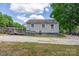 The exterior features a wooden ramp, vinyl siding, gravel driveway, and mature trees at 1415 Midlake Rd, Kannapolis, NC 28083