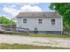 The exterior of a home features a wooden ramp, vinyl siding, gravel driveway, and mature trees at 1415 Midlake Rd, Kannapolis, NC 28083