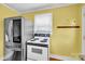 The kitchen features a stainless steel refrigerator, white stove top and yellow walls at 1415 Midlake Rd, Kannapolis, NC 28083