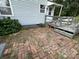 Home's brick patio area, featuring a small step-down deck, and green landscaping at 1415 Midlake Rd, Kannapolis, NC 28083