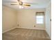 Neutral bedroom with carpet, ceiling fan, and a large window at 16612 Grapperhall Dr, Huntersville, NC 28078