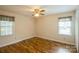 Bright bedroom with two windows, hardwood floors, and a ceiling fan at 16612 Grapperhall Dr, Huntersville, NC 28078