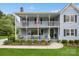 Inviting two-story home with a double porch and lush landscaping, enhancing its curb appeal at 16612 Grapperhall Dr, Huntersville, NC 28078