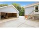 View into the detached garage with tools and a riding lawn mower. House has an entry door with stairs nearby at 16612 Grapperhall Dr, Huntersville, NC 28078