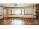Open living room with hardwood floors, a brick fireplace, and large windows offering a view at 16612 Grapperhall Dr, Huntersville, NC 28078