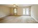 Spacious living room featuring neutral carpet, ceiling fan, and backyard access at 16612 Grapperhall Dr, Huntersville, NC 28078