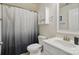 Bathroom featuring white vanity with sink, toilet, shower with gray-ombre curtain, and wall cabinet at 16831 Alydar Commons Ln, Charlotte, NC 28278
