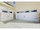 Spacious garage with two white doors, concrete driveway, and stone accents at 16831 Alydar Commons Ln, Charlotte, NC 28278