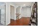 Bright hallway with hardwood floors and wooden railing leading to the upper level at 16831 Alydar Commons Ln, Charlotte, NC 28278