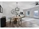 Bright dining area featuring modern light fixture, decorative clock and wall art and white trim and walls at 177 Briana Marie Way, Indian Trail, NC 28079