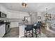 A modern kitchen with white cabinets, granite countertops, stainless steel appliances, and a breakfast bar with stools at 177 Briana Marie Way, Indian Trail, NC 28079