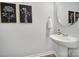 Stylish powder room with a pedestal sink, decorative art, and modern fixtures at 177 Briana Marie Way, Indian Trail, NC 28079