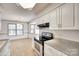 Well-lit kitchen featuring white cabinets, stainless steel appliances, and laminate wood flooring at 1866 Charter Dr, Rock Hill, SC 29732