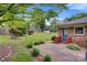 Backyard with a well-maintained lawn, mature trees, lush landscaping, and a small storage building at 1940 12Th Ne St, Hickory, NC 28601