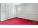Bedroom boasts red carpet, ample closet space, and a window that invites natural light at 1940 12Th Ne St, Hickory, NC 28601