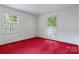 Bedroom with red carpet and natural light streaming through large windows with white shutters at 1940 12Th Ne St, Hickory, NC 28601