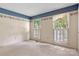Bedroom with blue wallpaper border and natural light from large windows with white shutters at 1940 12Th Ne St, Hickory, NC 28601