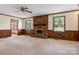 Comfortable living room featuring a brick fireplace, ceiling fan, and wood paneled walls at 1940 12Th Ne St, Hickory, NC 28601