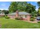 Brick home with a chimney, large windows, and well-maintained landscaping at 1940 12Th Ne St, Hickory, NC 28601