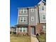 Three-story townhouse featuring gray siding, brick accents, and well-maintained landscaping at 2019 Tears Ln, Charlotte, NC 28217