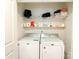 A tidy laundry room features a side-by-side washer and dryer with shelving and storage above at 2019 Tears Ln, Charlotte, NC 28217