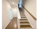 Inviting staircase with wood treads, white risers and walls, and a stained handrail at 2019 Tears Ln, Charlotte, NC 28217