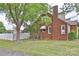 Exterior side view showcasing brick facade, white trim, and a well-manicured lawn with mature trees at 2036 1St Sw Ave, Hickory, NC 28602