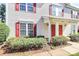 Exterior view of a townhouse featuring red shutters and well-kept landscaping at 2045 Flushing Ct, Charlotte, NC 28215