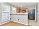 Compact kitchen with wood cabinets, tile countertops, a breakfast bar, and a black refrigerator at 2045 Flushing Ct, Charlotte, NC 28215