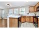 A kitchen area featuring wood cabinets, tile countertops, and a stainless steel sink with a window view at 2045 Flushing Ct, Charlotte, NC 28215