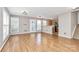 A cozy living room has hardwood floors, a large window, and a kitchen in the background at 2045 Flushing Ct, Charlotte, NC 28215