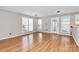 A well-lit and spacious living room features many windows for natural light and wood flooring at 2045 Flushing Ct, Charlotte, NC 28215