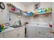 Functional laundry room with ample shelving, sink, and modern washer and dryer at 21216 Norman Shores Dr, Cornelius, NC 28031