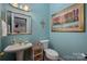 Stylish powder room featuring a pedestal sink, decorative mirror, and complementary wall art at 21216 Norman Shores Dr, Cornelius, NC 28031