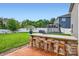 Outdoor kitchen with stone accents, bar seating, and a well-manicured backyard with green lawn at 2322 Tessa Trce, Clover, SC 29710
