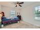 Comfortable bedroom with carpeted floor, ceiling fan, bright windows and a bed with colorful bedding at 2322 Tessa Trce, Clover, SC 29710