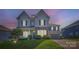 Charming two-story home at dusk featuring stone accents, gray siding, and a well-manicured lawn at 2322 Tessa Trce, Clover, SC 29710