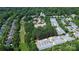 Expansive aerial view of a community with lush trees, a church, and rows of townhomes, showcasing a vibrant neighborhood at 239 N Faulkner Way, Davidson, NC 28036