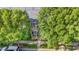 An exterior elevation highlights a traditional brick townhouse featuring dual balconies, lush trees, and walkway at 239 N Faulkner Way, Davidson, NC 28036