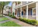 Row of brick townhomes with inviting front porches and blue shutters, complemented by manicured lawns and sidewalks at 239 N Faulkner Way, Davidson, NC 28036