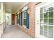Charming brick home with a covered front porch, blue shutters and stylish outdoor lanterns at 239 N Faulkner Way, Davidson, NC 28036