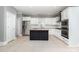 Modern kitchen with white cabinets, stainless steel appliances, and a black island with a granite countertop at 239 N Faulkner Way, Davidson, NC 28036