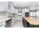 Well-lit kitchen with white cabinetry, stainless steel appliances, a breakfast bar, and an island at 239 N Faulkner Way, Davidson, NC 28036
