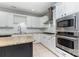 Well-lit kitchen features granite counters, white cabinets, and stainless steel appliances at 239 N Faulkner Way, Davidson, NC 28036