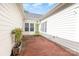 Rear brick patio provides outdoor living space with white exterior walls and vibrant green door at 239 N Faulkner Way, Davidson, NC 28036
